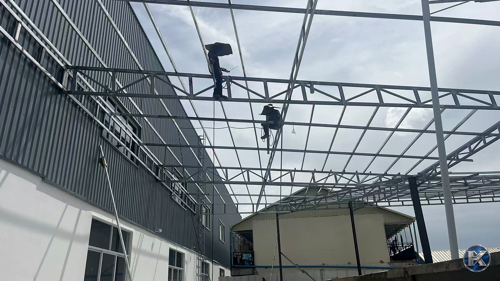 Steel warehouse frame under construction with roof trusses being installed